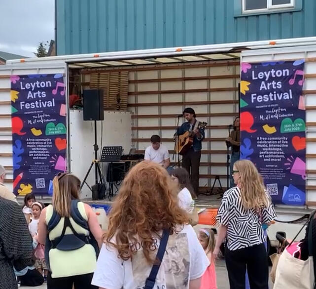 a dark blue logo for Leyton Arts Festival (26th - 27th July 2025) with colourful icons of a heart, a book, a flower and a squiggly line
